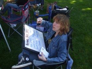 Author Stacey Longo writing out all the names of the authors appearing at the craft show