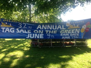 BB, the Books & Boos mascot hovering around the banner for the 32nd Annual Tag Sale on the Green