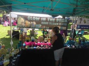 Christine Volpe arranging pieces of work at the Glow in the Dark Glass tent.