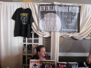 The New England Horror Writers table with author Scott Goudsward sitting behind it.