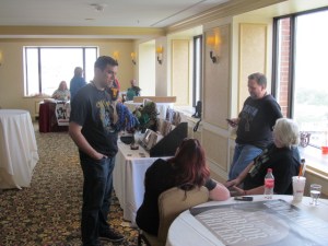 NEHW members Barry Dejasu and Scott Goudsward (both standing) and Laura Hickman and Jan Kozlowski (both sitting) at the NEHW table.