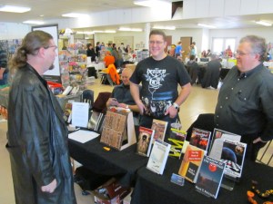Authors Gordon Bean and Dale T. Phillips talk to a visitor of the Books and Boos table.