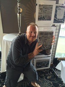 Artist and author Seth McCombs holding his book, Old Salty Dog.