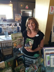 Artist/Illustrator Lisa Greenleaf holding up some of her work.