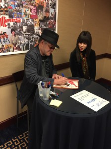 Musician Micky Dolenz signing an autograph for a fan.